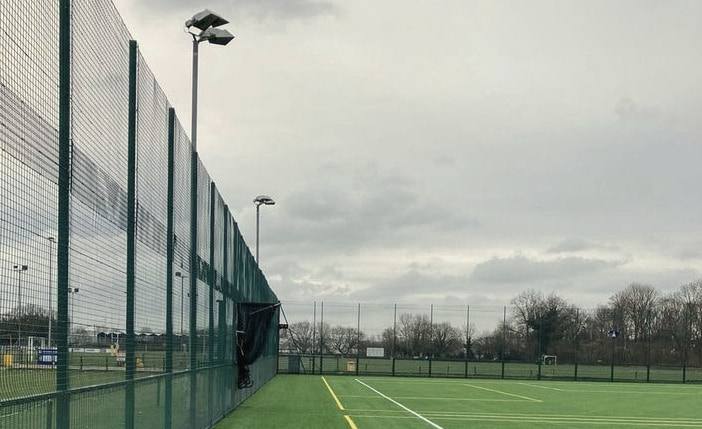 A training pitch enclosed by a high perimeter fence