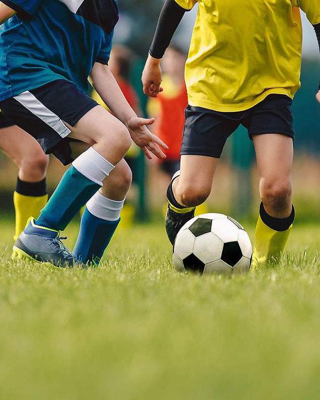 Young footballers in training kit competing for the ball