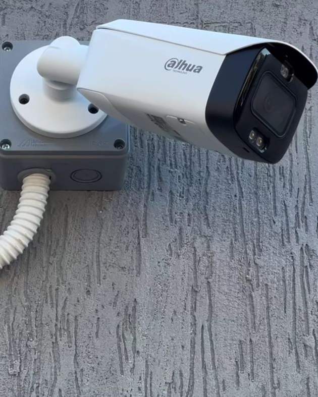 A Dahua bullet camera mounted on a textured wall