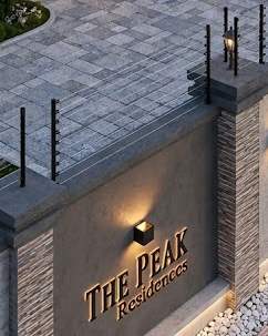 The entrance wall of The Peak Residence, with electric fence wires along the top